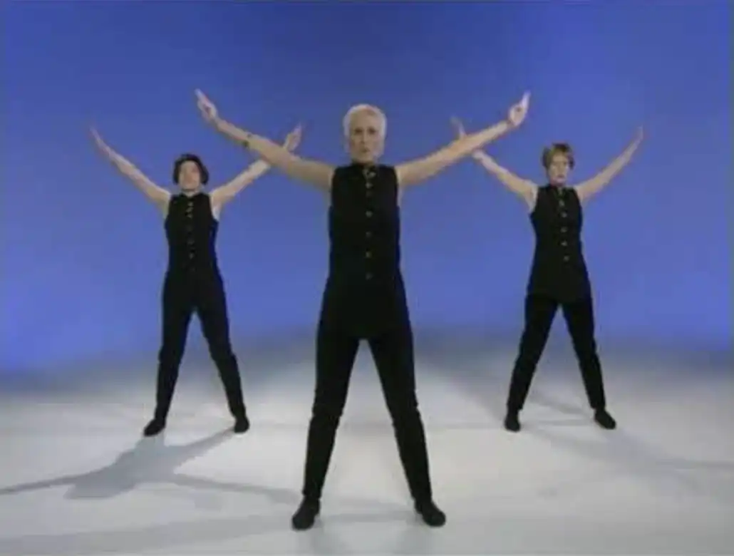 Three people holding their hands up against a cobalt background. 