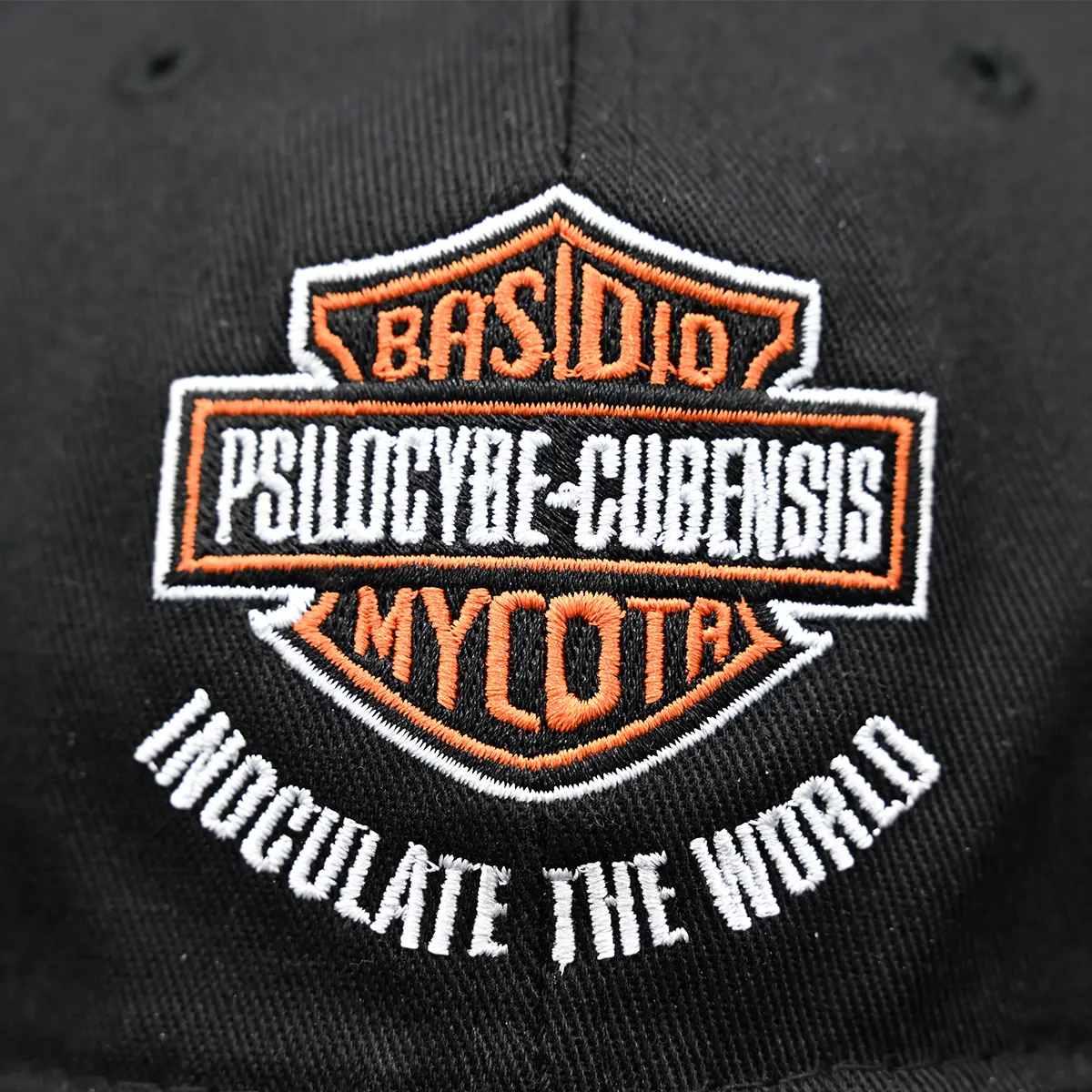 An embroidered orange and white design against a black cotton background